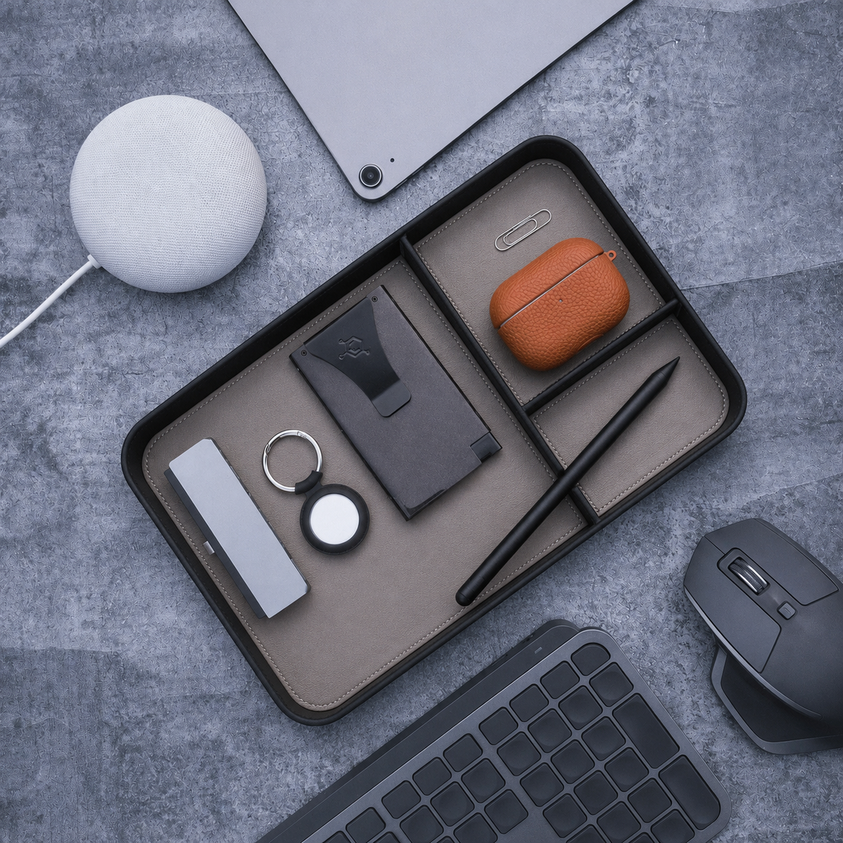 Desk organizer tray with everyday carry items, keyboard, mouse, and speaker on a desk